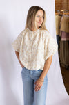 Woman wearing a floral blouse and blue jeans 