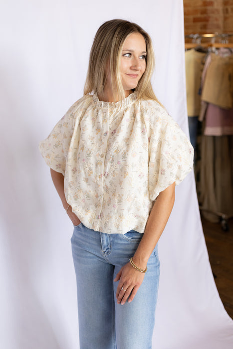 Woman wearing a floral blouse and blue jeans 