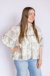 Woman wearing a floral blouse and light blue jeans 