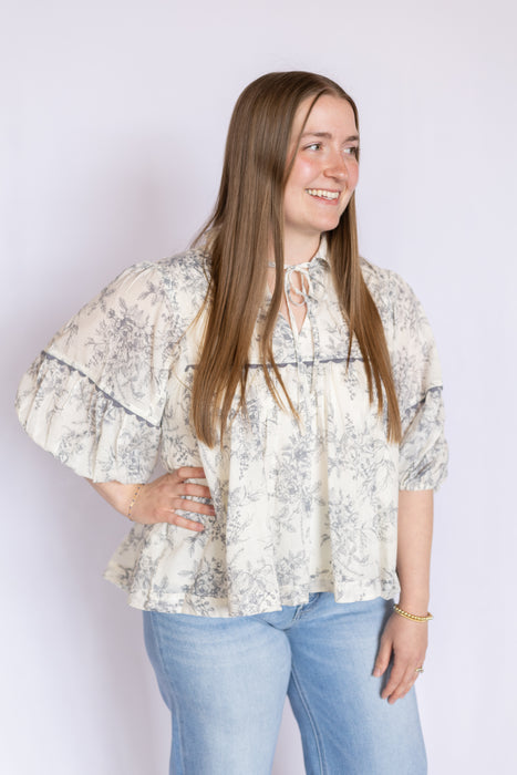 Woman wearing a floral blouse and light blue jeans 