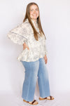 Woman wearing a floral blouse and blue jeans 