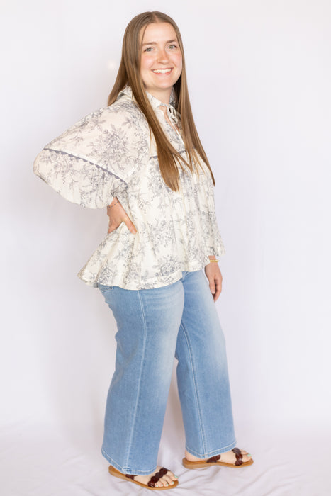 Woman wearing a floral blouse and blue jeans 