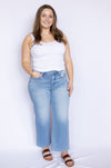 Woman wearing a white tank top and light blue jeans