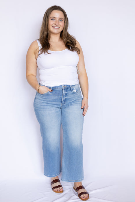 Woman wearing a white tank top and light blue jeans