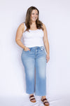 Woman wearing a white tank top and blue jeans 