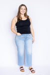 Woman wearing a black tank top and light blue jeans