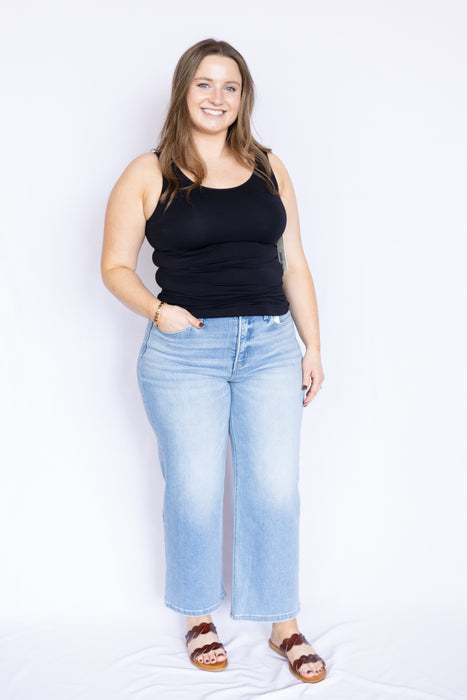 Woman wearing a black tank top and light blue jeans