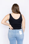 Person wearing a black tank top and blue jeans 