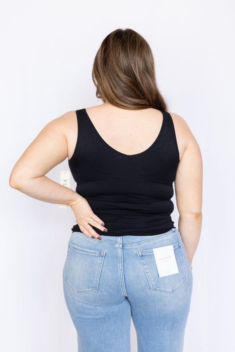 Person wearing a black tank top and blue jeans 