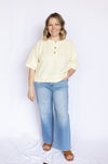 Woman wearing a light yellow blouse and blue jeans 