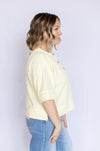 Woman wearing a light yellow top and blue jeans 