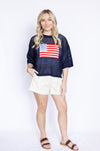 Woman wearing a navy blue sweater with an American flag design 