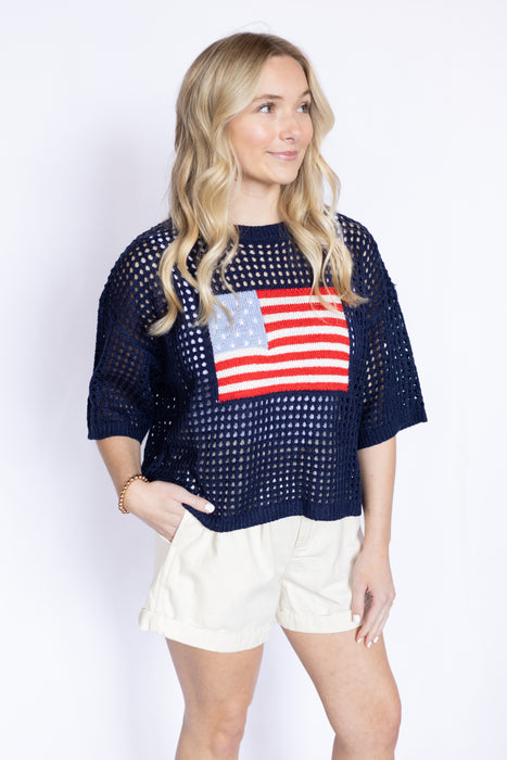 Woman wearing a navy blue top with an American flag design 