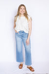 Woman wearing a white blouse and blue jeans 