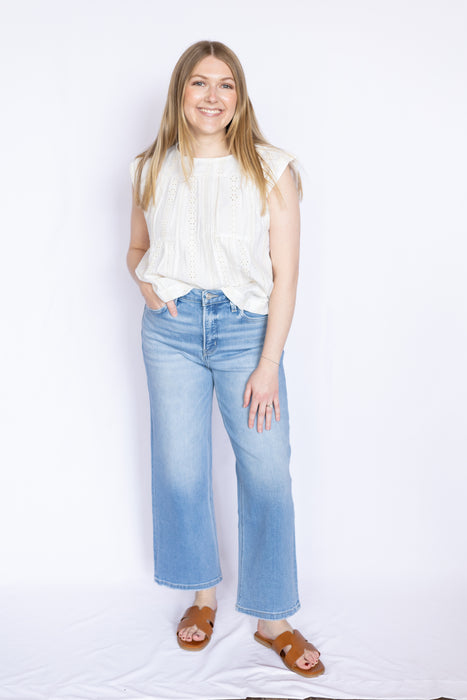 Woman wearing a white blouse and blue jeans 
