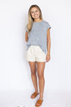 Woman wearing a blue top and white shorts 