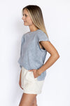 Woman wearing a blue shirt and white shorts 