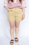 Person wearing a pink top and beige shorts 