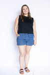 Woman wearing a black sleeveless top and blue shorts 