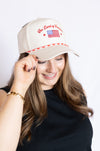 Woman wearing a beige cap with American flag design on a white background