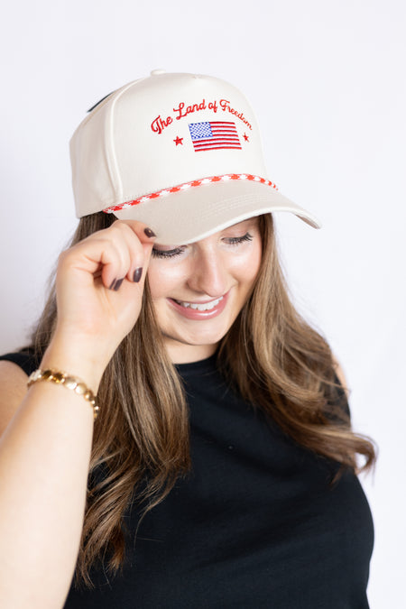 Woman wearing a beige cap with American flag design on a white background