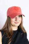 Woman wearing a red cap with a smiley face design
