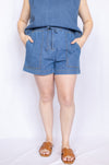 Person wearing blue shorts and a sleeveless top 