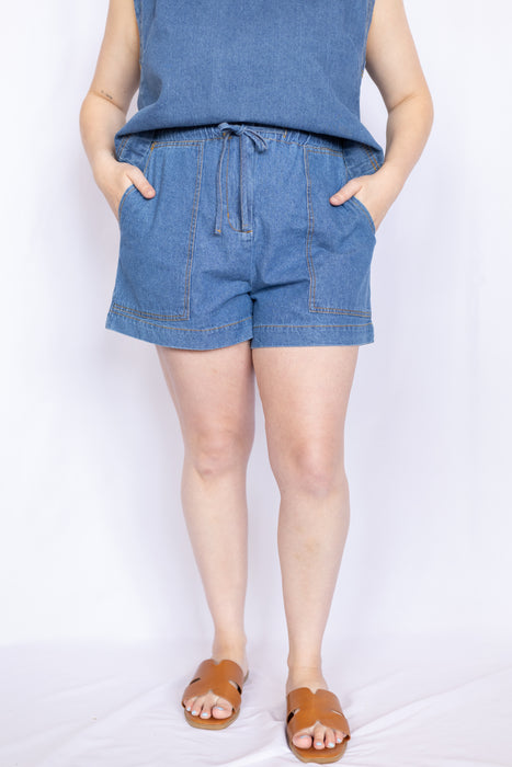 Person wearing blue shorts and a sleeveless top 