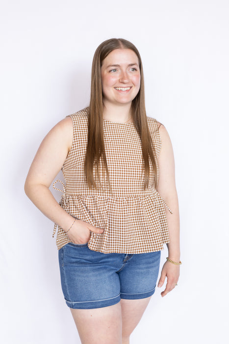 Woman wearing a checkered top and denim shorts 