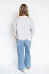 Person wearing a striped shirt and blue jeans 