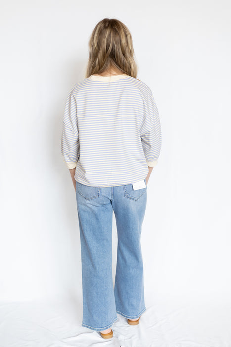 Person wearing a striped shirt and blue jeans 