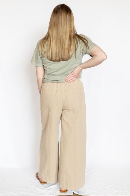 Person wearing a green top and beige pants 