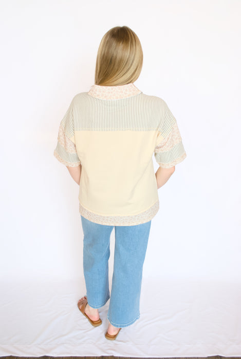 yellow floral and stripe top with blue jeans and brown sandals