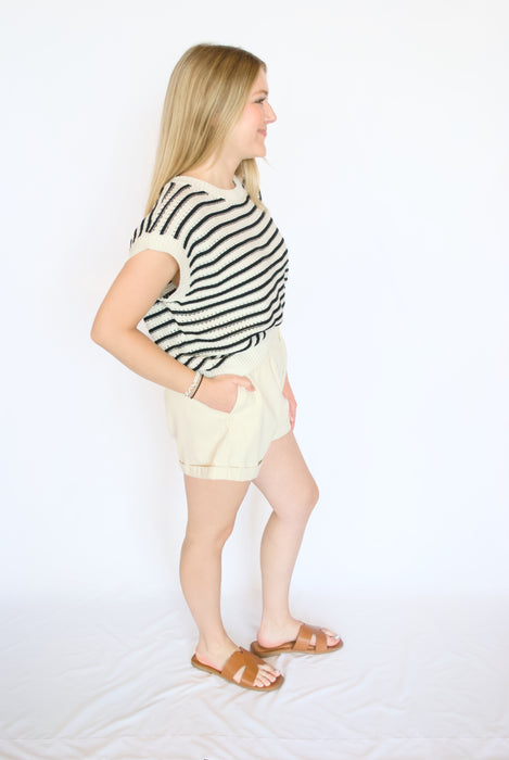 Black sleeveless striped sweater tank with white shorts
