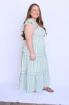 Woman wearing a light green dress with ruffled sleeves 