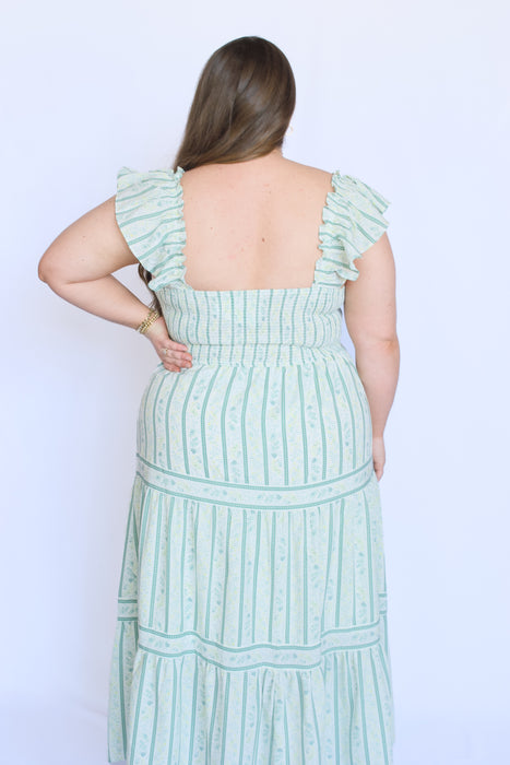 Woman wearing a light green dress with vertical stripes 