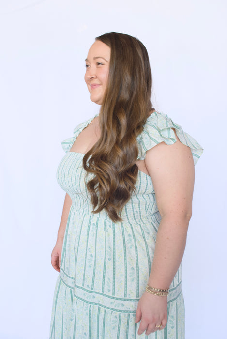 Woman wearing a light green dress with ruffled sleeves 