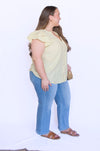 Woman wearing a yellow blouse and blue jeans 