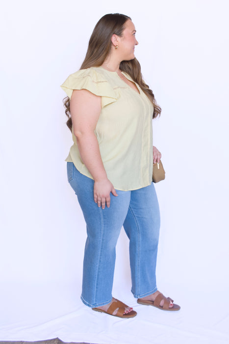 Woman wearing a yellow blouse and blue jeans 
