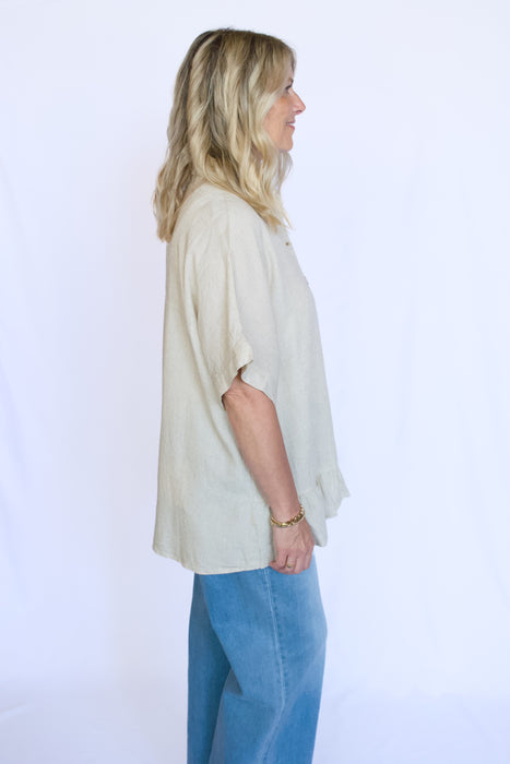Woman wearing a beige blouse and blue pants 