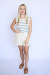 Woman wearing a striped sleeveless top and white shorts 