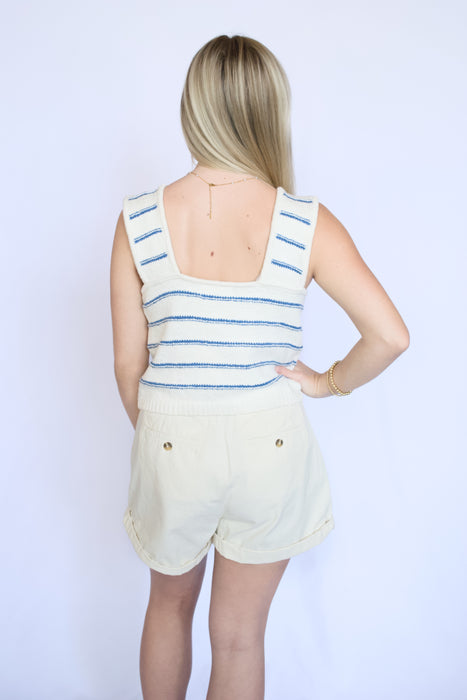 Person wearing a striped sleeveless top and shorts 