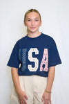 Person wearing a blue 'USA' t-shirt with decorative elements 