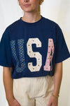Person wearing a navy blue t-shirt with 'USA' printed on it 