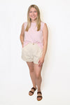 Woman wearing a pink sleeveless top and beige shorts 