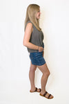 Woman wearing a gray sleeveless top and blue denim shorts