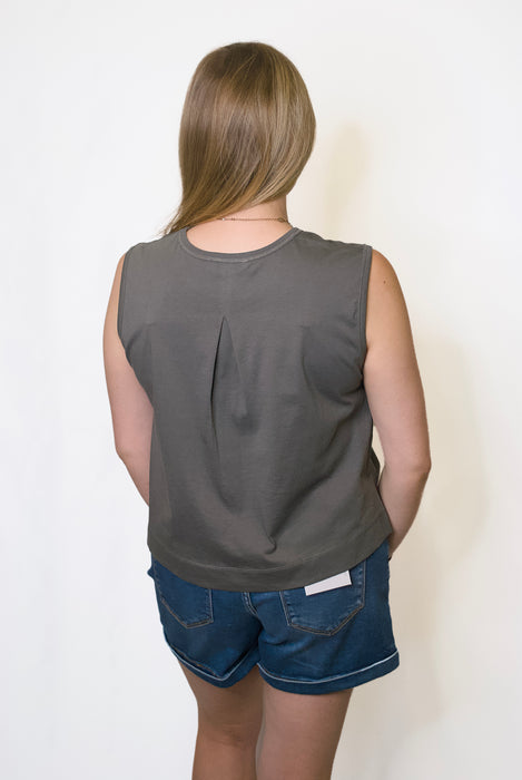 Person wearing a gray sleeveless top and blue shorts 
