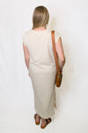 Woman wearing a beige dress with a brown bag