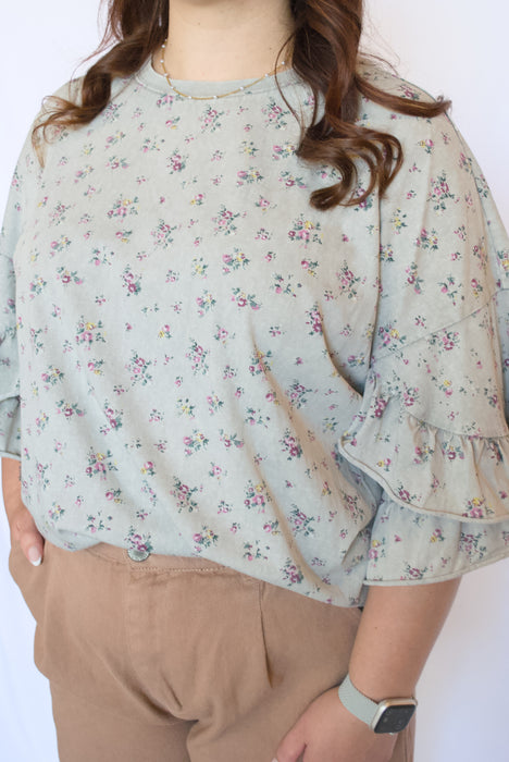 Woman wearing a light floral blouse with ruffled sleeves 