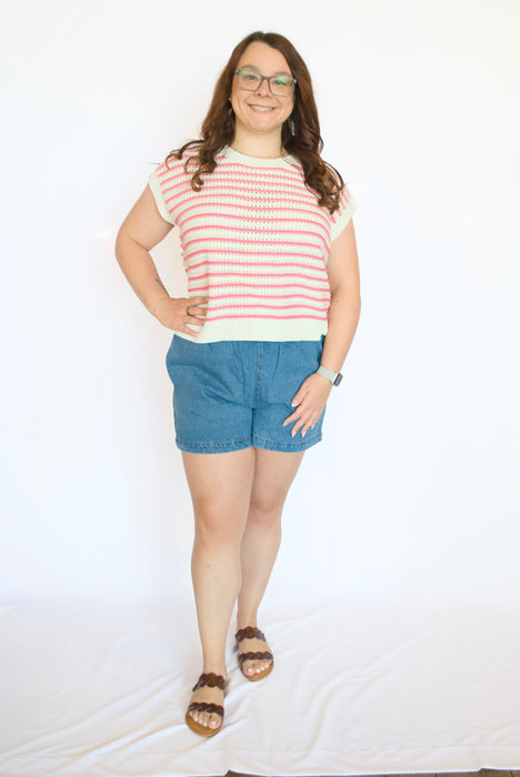 Person wearing a red and white striped shirt and blue shorts 
